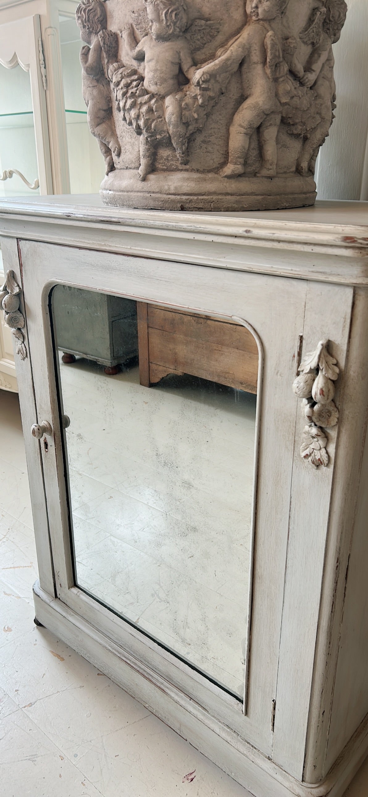 Petite antique cabinet with foxed mirrored door