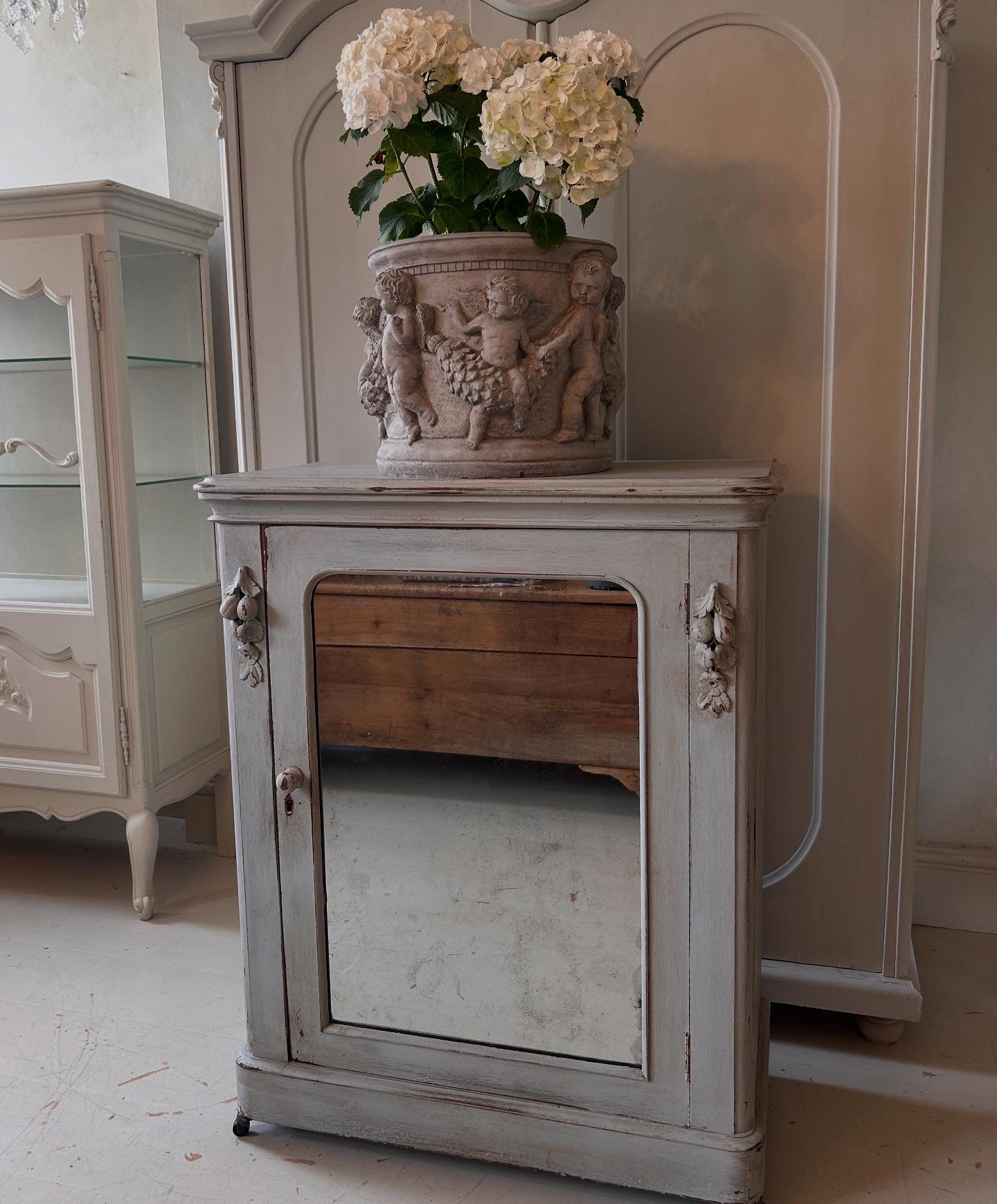 Petite antique cabinet with foxed mirrored door